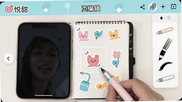 悦甜APP内页编辑界面，用户正在拖拽动态贴纸到电子手账上，画面中有多种彩色贴纸和手绘笔刷工具，界面风格可爱清新，突出“悦甜”LOGO